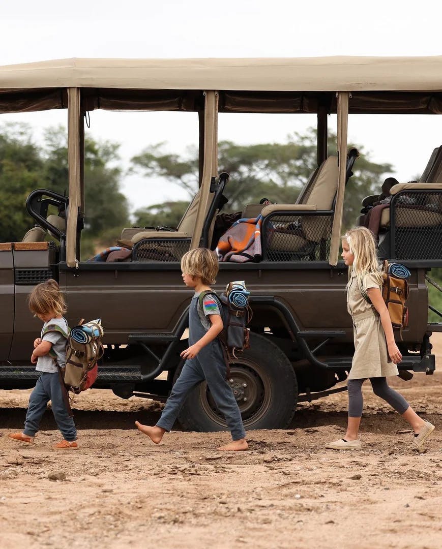 Children walking barefoot infront of a vehicle